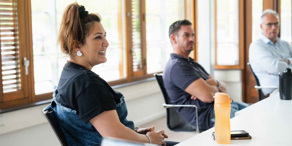 banner-4 Ayse en Michel luisteren aandachtig naar een collega